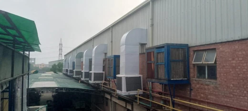 Industrial evaporative cooling units with ducting on a factory wall